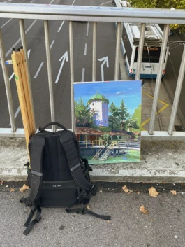 Das fertige Gemälde des Männerbads am Schanzengraben in Zürich steht auf der Rosengarten-Brücke, angelehnt an das Geländer. 