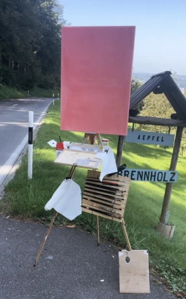 Eine pink grundierte Leinwand steht auf einer Feldstaffelei am Rorschacherberg. 