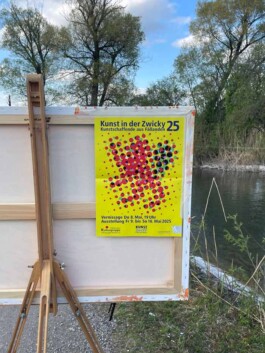 Eine Leinwand steht auf einer Feldstaffelei. Auf der Rückseite klebt ein Plakat der Ausstellung «Kunst in der Zwicky 2025» 