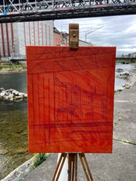 Eine orange grundierte Leinwand steht auf einer Feldstaffelei. Man sieht die Skizze der Szenerie – das Kornhaus direkt an der Limmat. 